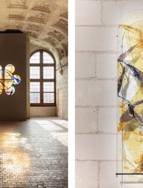 Partie gauche : Nous voyons une grande salle ancienne avec des murs et un plafond voûté en pierre sculptée. Deux grandes fenêtres à arc en plein cintre laissent entrer la lumière naturelle. Entre ces fenêtres, un mur moderne gris est installé, percé de huit cercles formant une fleur stylisée. Ces cercles sont constitués de vitraux colorés aux teintes chaudes (orange, jaune) et quelques touches de bleu et de violet, créant des motifs abstraits. La lumière traverse les vitraux et projette leurs couleurs vives