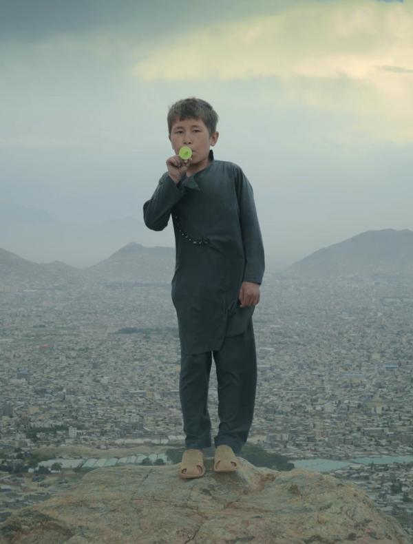Un jeune garçon jouant du kazoo sur le haut plateau près de Kaboul