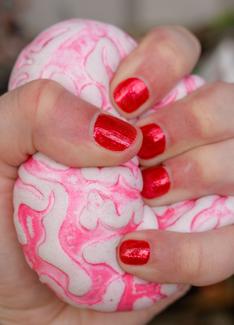 Photo de la main de benoît Piéron serrant une boule anti-stress blanche et rose.