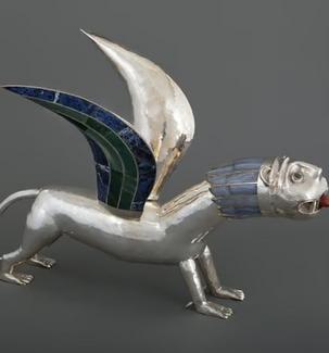 Sculpture en métal poli représentant une créature mythologique hybride, dotée d’un corps de lion et d’ailes incrustées de motifs colorés. L’œuvre se distingue par ses lignes stylisées et son expression saisissante.