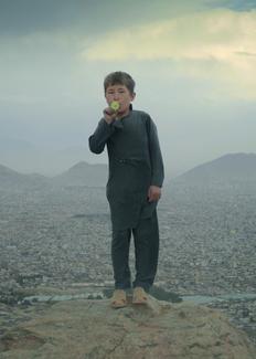 Un jeune garçon jouant du kazoo sur le haut plateau près de Kaboul