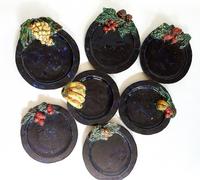 Sept assiettes à dessert, céramique émaillée bleu marine décor fruits D=17-19 cm