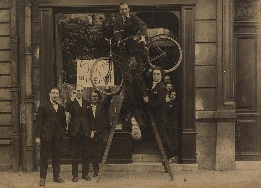 Exposition Max Ernst au Sans-Pareil, 1920, De gauche à droite : René Hilsum, Benjamin Péret, Charchoune, Philippe Soupault, Jacques Rigaut (la tête en bas), André Breton